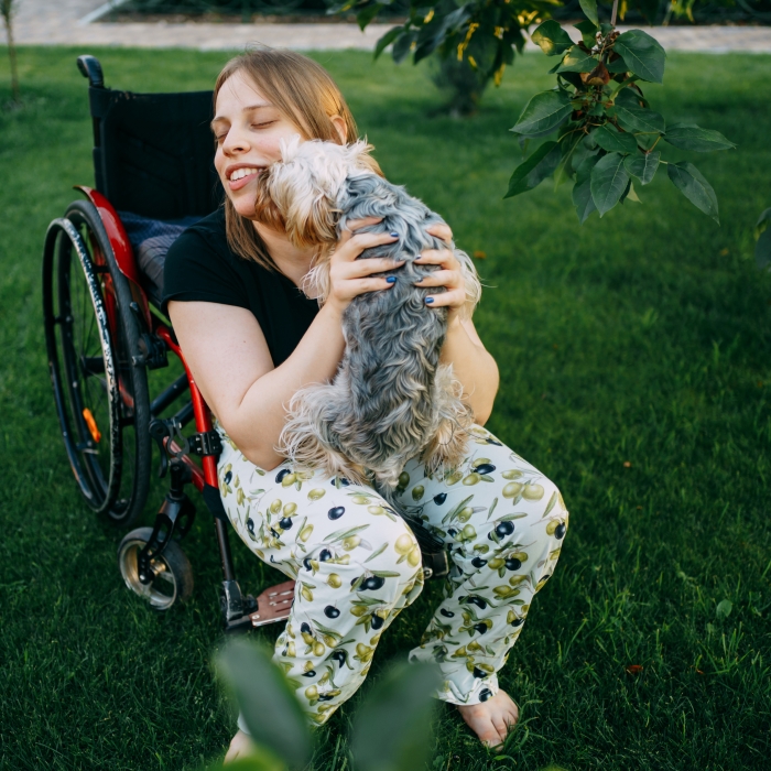 Living with a disability – Wheelchair user with their dog in the garden