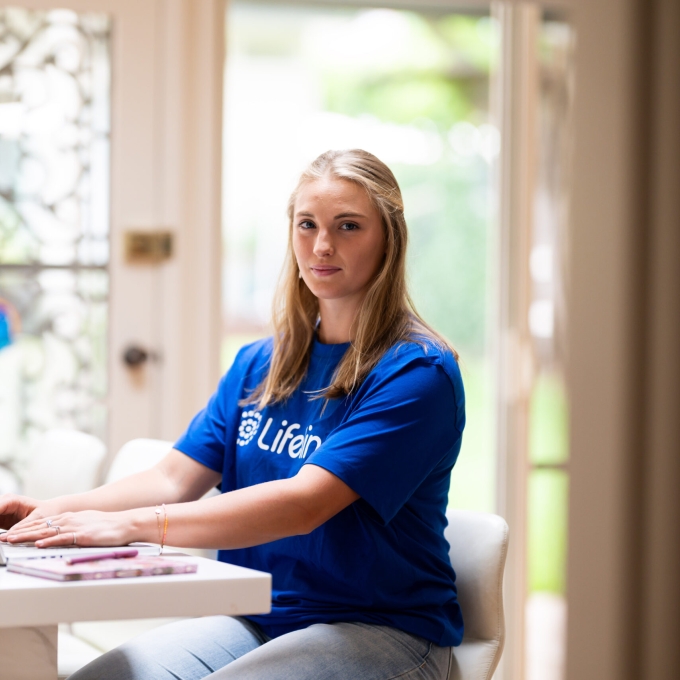 woman in lifeline t shirt typing on a laptop