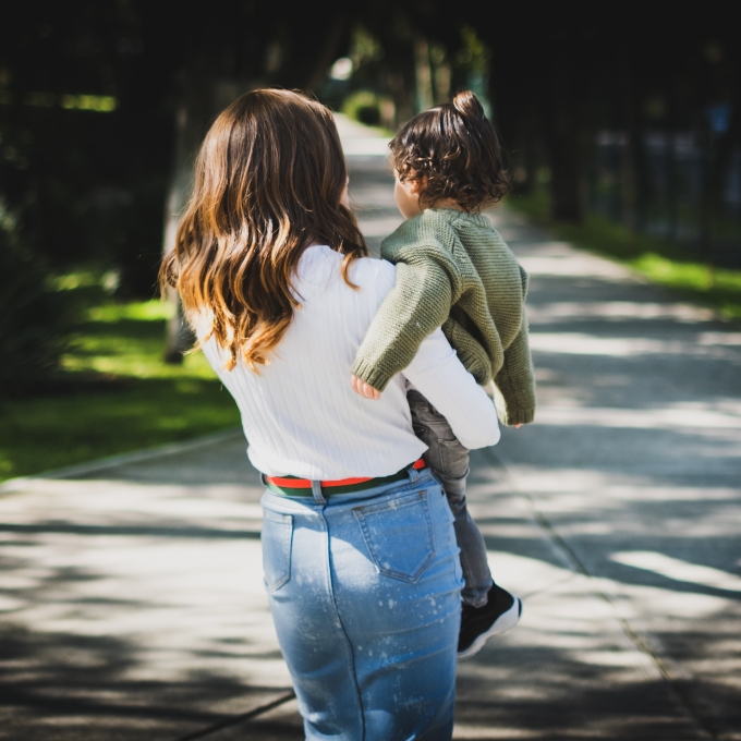 Woman with back to camera, holding child