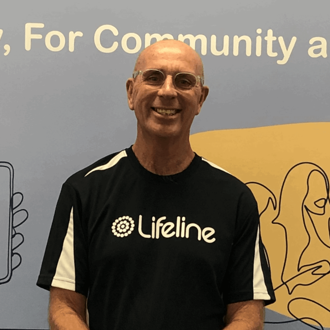 man wearing glasses and lifeline t shirt smiling
