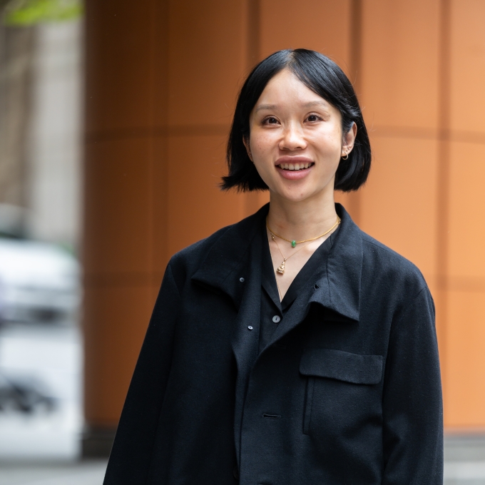 Anne Nguyen in black clothing, standing on the steps of an office building in Sydney CBD
