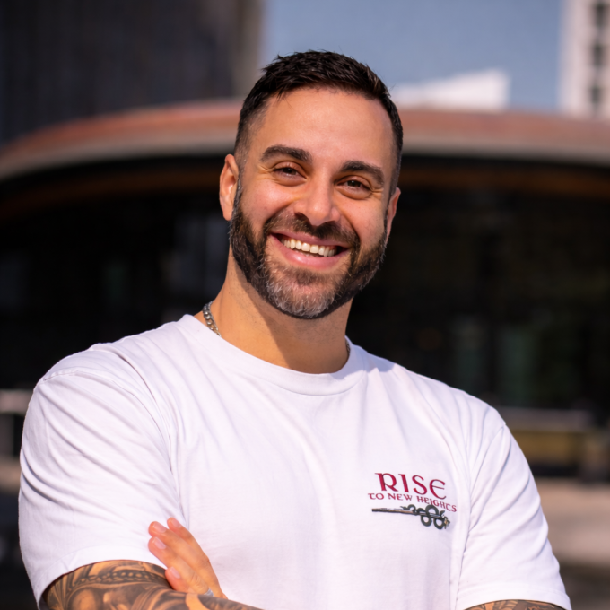 Michael Elwan, smiling, arms crossed, in warm daylight