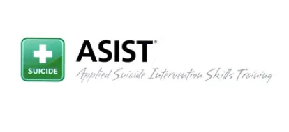 The image displays the ASIST logo. On the left, a green square with rounded corners features a white cross symbol. Below the cross, the word "SUICIDE" is written in white capital letters. To the right, "ASIST" is in large, bold black capital letters, with a small registered trademark symbol. Below "ASIST," the full name "Applied Suicide Intervention Skills Training" is written in a smaller, lighter gray, italicized font. The background is white.